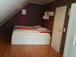 ein kleines Bett in einem Zimmer mit Dachgeschoss in der Unterkunft Gottschalk-Ferienhaus-Ostsee in Neustadt in Holstein