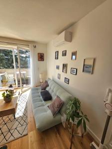 a living room with a blue couch and a table at L'hippique - Parking - vue Pyrénées - Balcon in Pau