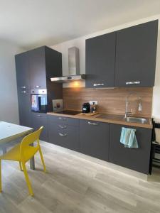 a kitchen with a sink and a table with a yellow chair at Le finestre sul mare in Rio Marina