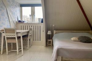 Schlafzimmer mit einem Bett, einem Schreibtisch und einem Tisch in der Unterkunft t Heerenhuys in Wageningen
