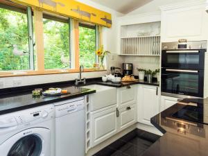 a kitchen with white cabinets and a washer and dryer at 2 Bed in Beaulieu NFL71 in Beaulieu
