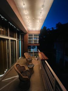 ein Balkon mit Stühlen und einem Tisch auf einem Gebäude in der Unterkunft Luna & Sol 2BHK in Kasauli