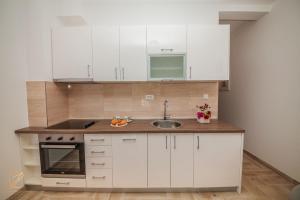 eine Küche mit weißen Schränken und einem Waschbecken in der Unterkunft Apartment Rosemary - Happy Rentals in Herceg-Novi
