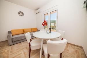 ein Wohnzimmer mit einem Tisch, Stühlen und einem Sofa in der Unterkunft Apartment Rosemary - Happy Rentals in Herceg-Novi