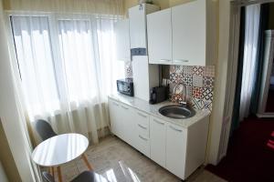 a small kitchen with a sink and a table at Charma Residence in Sibiu