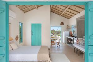 a bedroom with a bed with a blue door at Vila da Falésia in Corumbau