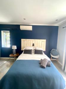 a blue bedroom with a large bed with two pillows at Stay on Main - Studio Blue in Paarl