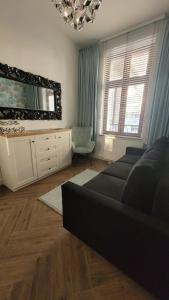 a living room with a couch and a mirror at APARTAMENT JARACZA 28/12 in Słupsk