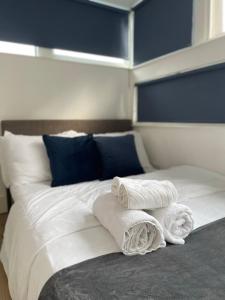 - un lit avec 2 serviettes assises au-dessus dans l'établissement Modern flat & balcony in historic West Kensington, à Londres