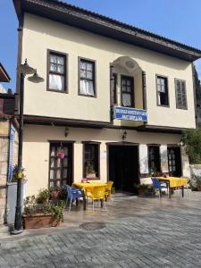 a building with tables and chairs in front of it at Dedehan Pansiyon in Antalya
