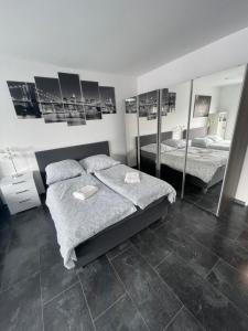 a bedroom with two beds and mirrors on the wall at Exklusive Moderne Wohnung Gießen Stadtnähe mit Balkon in Annerod