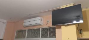 TV de pantalla plana colgada en la pared en Hostal La GRAN Familia en Manta