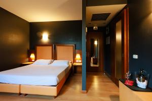 una camera con un grande letto e due tavoli con lampade di Hotel Villa Delle Rose - Malpensa a Oleggio