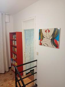 une chambre avec un tableau sur le mur et une étagère à livres dans l'établissement Albergo Belvedere, à Albissola Marina