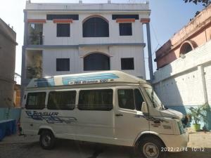 a white van parked in front of a building at Milan Palace Deoghar in Deoghar