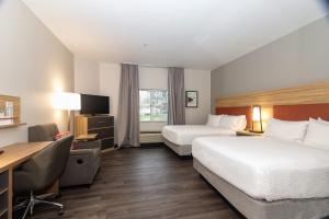 Habitación de hotel con 2 camas y escritorio en Candlewood Suites New Bern, an IHG Hotel, en New Bern