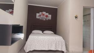 a small bedroom with a bed and a shower at Pousada Beija flor in Extrema