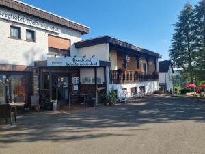 een gebouw met een veranda en een balkon bij Berghotel Waidmannsheil in Battenberg