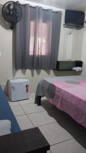 a bedroom with a purple bed and a window at Pousada Beija flor in Extrema