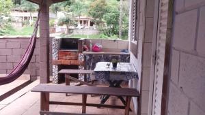 an outdoor patio with a table and a hammock at Pousada Beija flor in Extrema