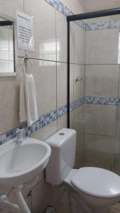 a bathroom with a toilet and a sink and a shower at Pousada Beija flor in Extrema