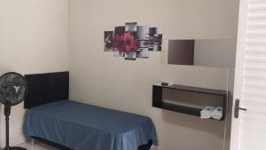 a room with a blue bed and a fan at Pousada Beija flor in Extrema