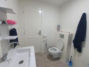 a white bathroom with a toilet and a sink at Stunning Penthouse with Sea and Castle View (2BDR) in Sousse