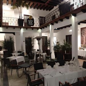 une salle à manger avec des tables et des chaises blanches dans l'établissement Hotel Casa las Mercedes, à Oaxaca