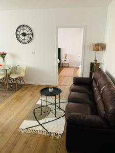 a living room with a leather couch and a table at Iris Apartment in Piatra Neamţ