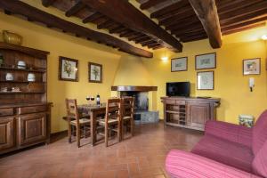 a living room with a kitchen with a table and a stove at Antiche Mura in Barberino di Val dʼElsa