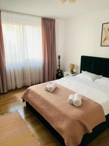 a bedroom with a bed with two towels on it at Iris Apartment in Piatra Neamţ +17 photos