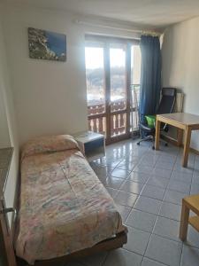 a bedroom with a bed and a table and a balcony at Casa Viarago in Pergine Valsugana