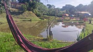 a hammock in front of a pond at Pousada Beija flor in Extrema