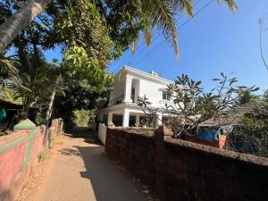 a white house with a fence in front of it at Ocean's Edge By Zac in Calangute