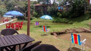 a patio with chairs and a table and a pond at Pousada Beija flor in Extrema