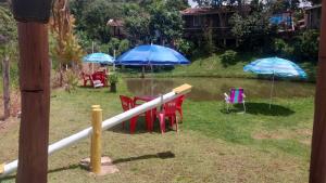 a group of tables and chairs with umbrellas at Pousada Beija flor in Extrema +37 photos