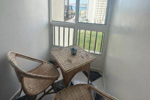 stół i krzesła w pokoju z dwoma oknami w obiekcie Beautiful Sea View Apartment in Tangier w mieście Tanger