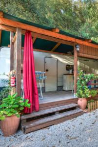 a house with a red umbrella and some plants at Chalet nel Verde di Cavo in Cavo