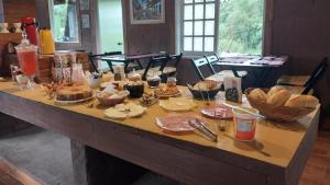 einen Tisch mit Essen darüber in der Unterkunft Pousada Beija flor in Extrema