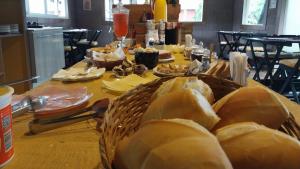 a table with a basket of bread on it at Pousada Beija flor in Extrema