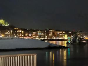 a view of a city at night with a harbor at Cozy apartment by Opera house in Oslo