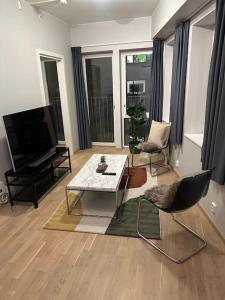 uma sala de estar com uma televisão e uma mesa e cadeiras em Cozy apartment by Opera house em Oslo
