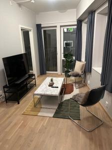 uma sala de estar com uma televisão e uma mesa e cadeiras em Cozy apartment by Opera house em Oslo