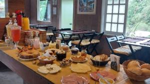 a table with a bunch of pastries on it at Pousada Beija flor in Extrema