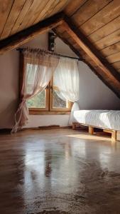Cette chambre mansardée comprend 2 lits et une fenêtre. dans l'établissement Jaśkowa Stodoła, à AdamÃ³w