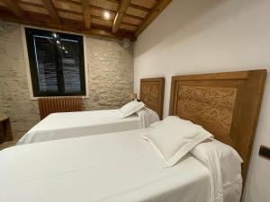 2 camas blancas en una habitación con ventana en Hotel Històric en Girona
