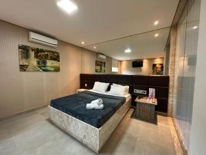 um quarto com uma cama grande e um espelho em Motel Orion - Belo Horizonte em Belo Horizonte