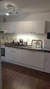 a kitchen with white cabinets and a counter top at Ferienwohnung Am Wald in Michendorf