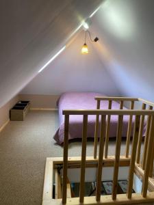 a attic room with a bed and a staircase at Domek letniskowy in Skępe