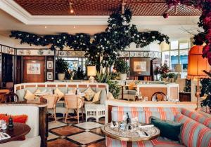un restaurant avec des canapés, des tables et des chaises dans l'établissement Charming 1BR Flat in the Heart of City of London, à Londres